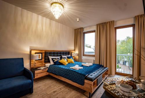 瓦乌奇APARTHOTEL Wałcz的一间卧室配有一张床、一张沙发和一个窗口