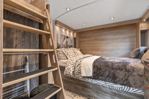 安姆罗斯The Escape - Luxury Pod Close to Beach的一间卧室设有两张床和木墙