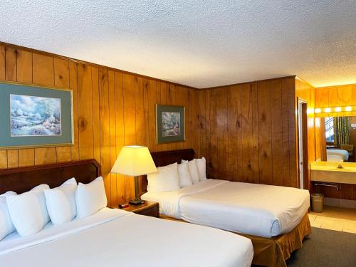 尤里卡斯普林斯Traveler's Inn的配有木墙的酒店客房内的两张床