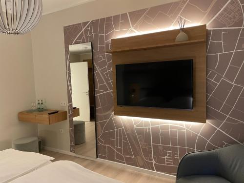 科斯费尔德哈塞尔霍夫酒店及餐厅的卧室配有壁挂式平面电视