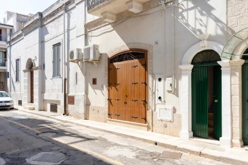 滨海波利尼亚诺WePuglia - Catarì的街道上设有木门的建筑