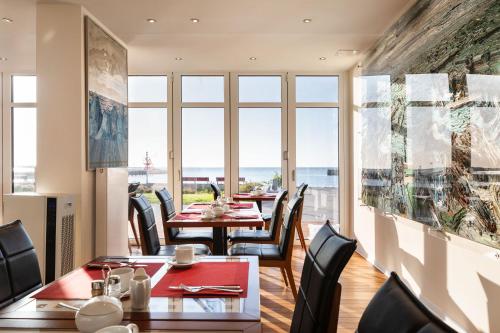 黑尔戈兰岛英叙兰纳瑞克曼酒店的一间设有桌椅的海景餐厅