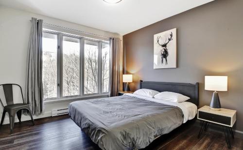斯托纳姆569 chemin du Hibou的一间卧室设有一张床和一个大窗户