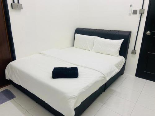 Kampong BembanI-STAY 01 JK Roomstay的一张睡床,上面有一个黑袋
