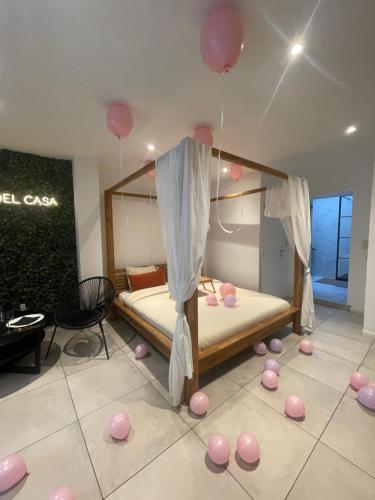 列日Spa Palawan privé avec jacuzzi et sauna Liège的一间房间,地板上配有一张带粉红色气球的床
