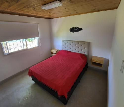门多萨Posada y Cabañas "Finca El Rincón de Lunlunta"的一间卧室配有一张红色床罩的床