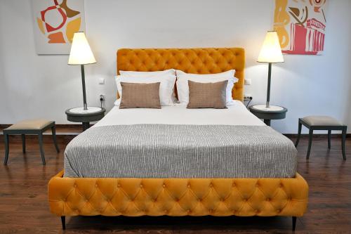 雅典Stylish Apartment, Acropolis view的一间卧室配有一张带两盏灯的大型橙色床
