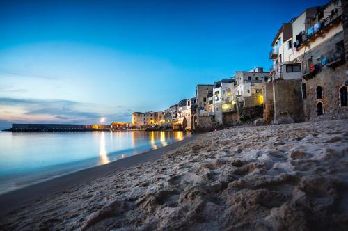 切法卢Archi Bianchi的享有海滩的夜间美景,设有建筑