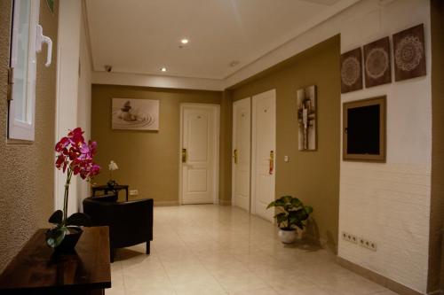 马德里Hostal Ártico的走廊上设有一扇门和鲜花的房间