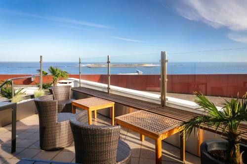 黑尔戈兰岛Hotel auf den Hummerklippen的一个带桌椅的海景阳台