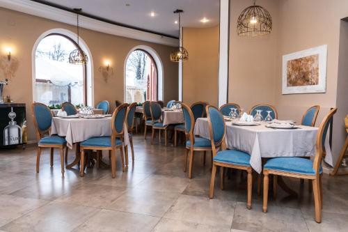 Urziceni皇家酒店的一间配备有桌子和蓝色椅子的用餐室