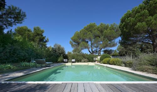 埃加利埃Maison Les Chênes的花园内的游泳池,设有木甲板