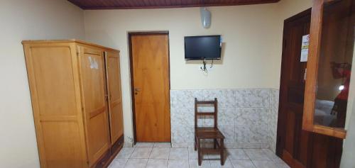 伊瓜苏港Hospedaje Jose Gorgues的配有电视、椅子和门的房间