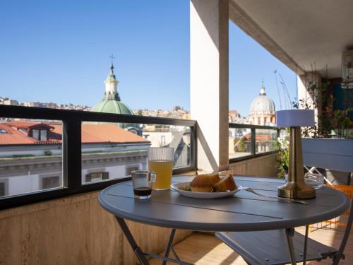 那不勒斯波旁酒廊住宿加早餐旅馆的阳台上的桌子上放着一盘食物和饮料