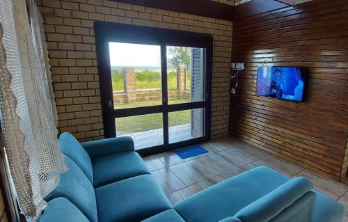 托雷斯Residencial Itapeva的客厅配有蓝色的沙发和电视
