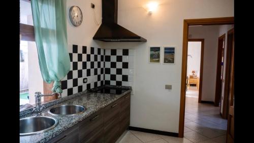 卡皮塔纳villa Orchidee Sardegna的厨房配有两个水槽和墙上的时钟
