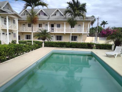 拉纳韦贝Club Caribbean Apartments的大楼前带游泳池的房子