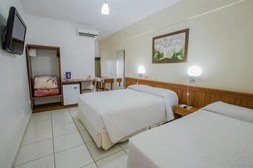 伊瓜苏Foz Presidente Economic Hotel的酒店客房设有两张床和电视。
