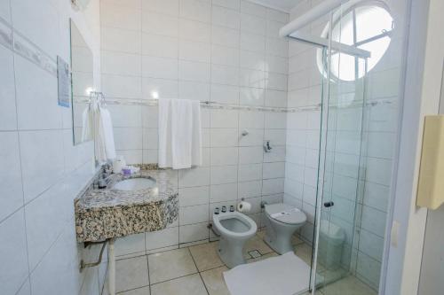 伊瓜苏Foz Presidente Economic Hotel的浴室配有卫生间、盥洗盆和淋浴。