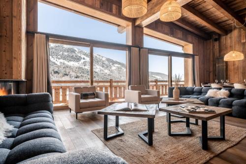 美贝尔Chalet Amis - Meribel - Pool moovie and play room的带沙发和大窗户的客厅