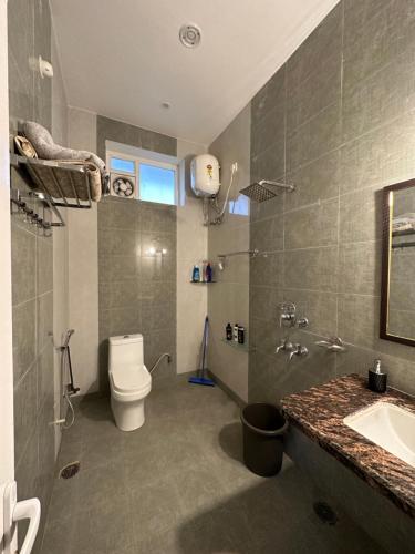 瓦拉纳西Kaashi Flora - Luxury 3BHK的浴室配有白色卫生间和盥洗盆。