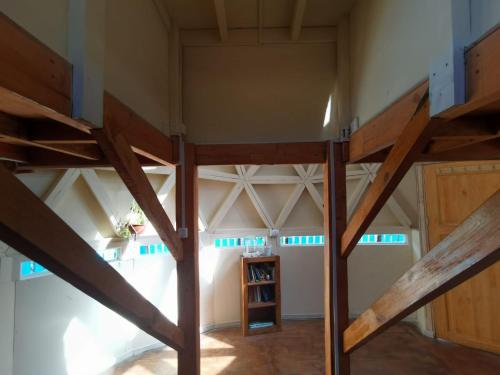 梅利佩乌科Alquimia del Hualle的阁楼间设有高架床和木梁。