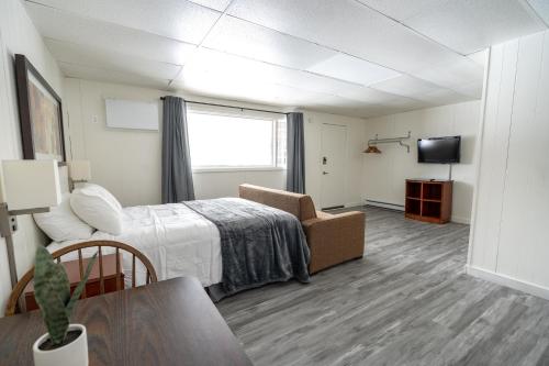DeerwoodCuyuna Lakes Stay的客房设有床、沙发和电视。