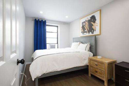 纽约350-2A Prime gramercy Newly renovated 1BR sleeps 4的一间卧室配有一张蓝色窗帘的床
