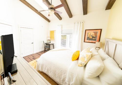 MembertouBack Home Bed and Breakfast的卧室配有白色的床和吊扇