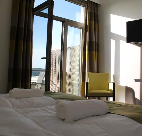 TubizeMondo hôtel的一间卧室设有一张床,享有海景