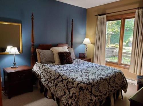 蒙特朗布朗Chalet-Style Condo - 5 minutes to Lifts and village!的一间卧室设有一张床和一个窗口