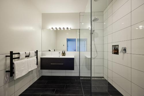 凯库拉Koura Bay Golf Resort的一间带水槽和玻璃淋浴的浴室