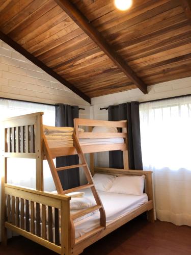 巴尼奥斯High-end Holiday Cabin - Tungurahua Hot Springs的配有木天花板的客房内的两张双层床