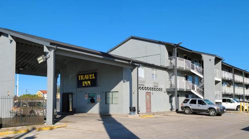 圣安东尼奥Travel Inn San Antonio的停车场内有停车位的建筑物