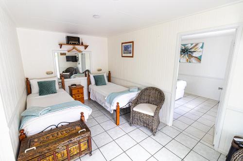 ChillagoeChillagoe Cabins and Tours的一间卧室配有两张床和椅子