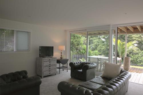 奥克兰TreeTops的客厅配有沙发、椅子和电视
