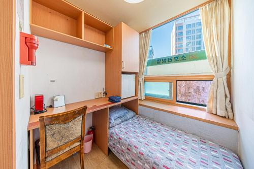 首尔Dream Single House的小房间设有书桌、床和窗户