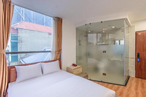 河内Coco Hotel Cau Giay的一间卧室设有一张床和一个玻璃淋浴间