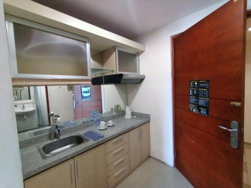 泗水高点服务式公寓酒店的一个带水槽和木门的厨房