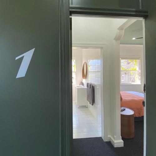 悉尼Blues Point Hotel的一间设有一扇门的客房,可通往一间卧室