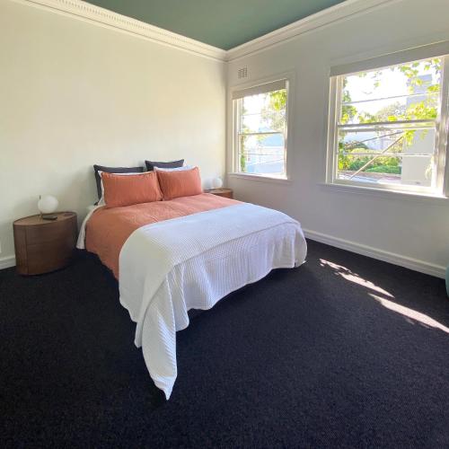 悉尼Blues Point Hotel的一间卧室设有一张床和两个窗户。