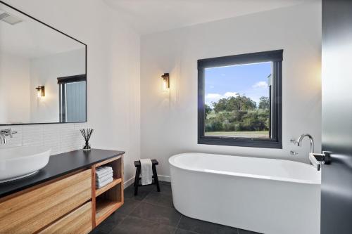 Rosa GlenRuse Estate Retreat Margaret River的带浴缸、水槽和窗户的浴室