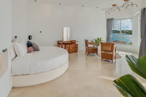 波普托Ampersand Resort的白色的客厅配有白色的床和椅子
