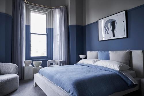 巴拉腊特Hotel Vera Ballarat的蓝色卧室,配有床和椅子
