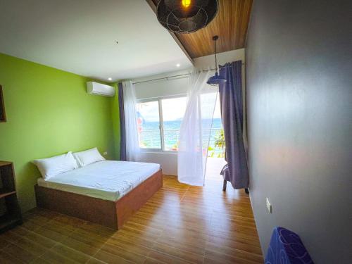 马比尼Anilao Ocean View Guest House的一间卧室设有一张床和一个大窗户