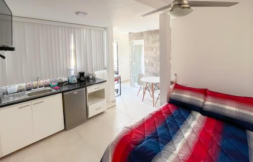 韦拉克鲁斯Habitaciones Amubladas Logos II的一间卧室配有一张色彩缤纷的床和一间厨房