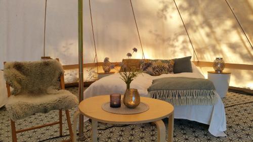 诺托登Lystang Glamping & Cabins的一间卧室配有一张床、一把椅子和一张桌子