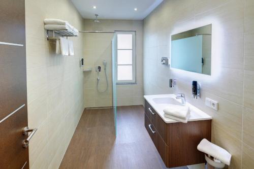 福森福森酒店的浴室配有盥洗盆和带镜子的淋浴