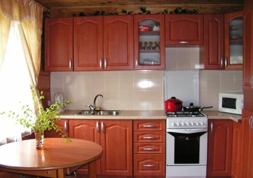 SventePakrasti的厨房配有木制橱柜、桌子和炉灶。