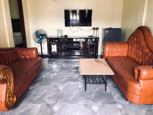 武吉拉旺武吉拉旺托马斯休闲度假旅馆的客厅配有两张真皮沙发和一张茶几